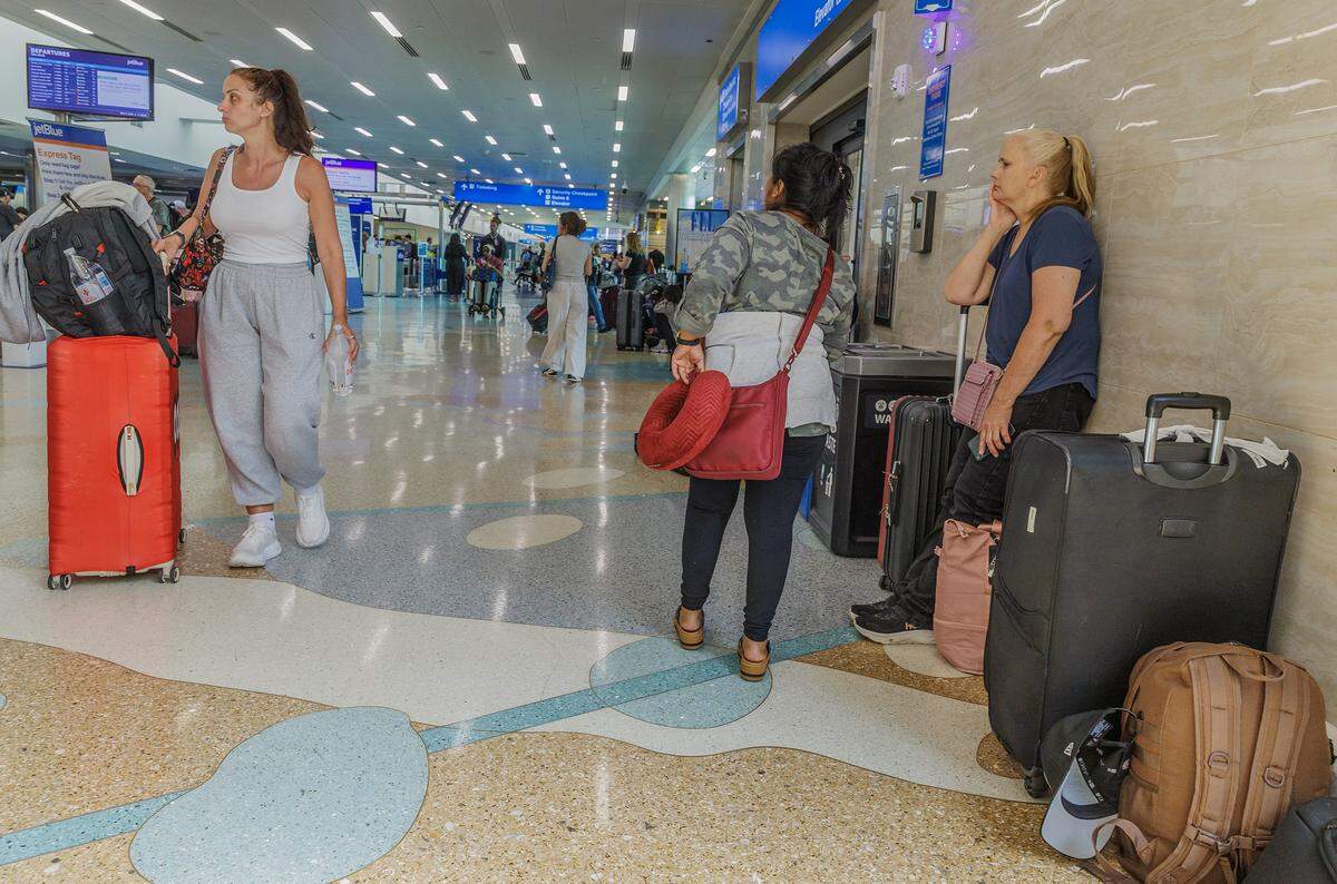 Raquel Velazquez, center, waits at Fort Lauderdale-Hollywood International Airport after her flight to Guatemala on Spirit Airlines was canceled on Saturday, May 2, 2026.